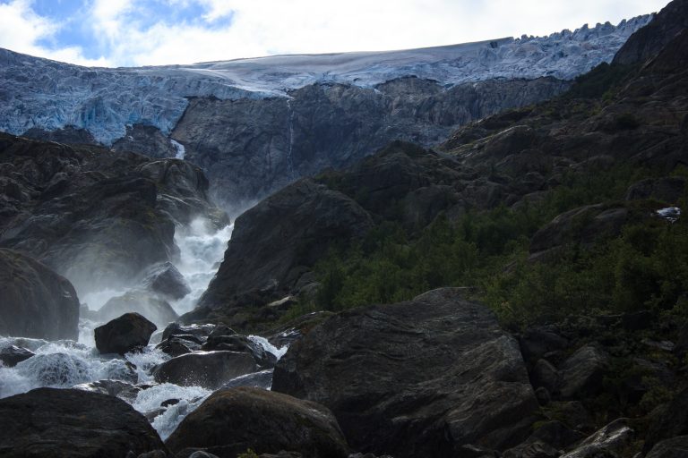 Wandern zum Buarbreen im Folgefonna Nationalpark, Wanderung in der Nähe von Odda mit Aussicht auf den Gletscher Buarbreen und Wasserfälle, Blick auf den Gletscher Buarbreen und den strömenden Fluss, große umliegende Felsen