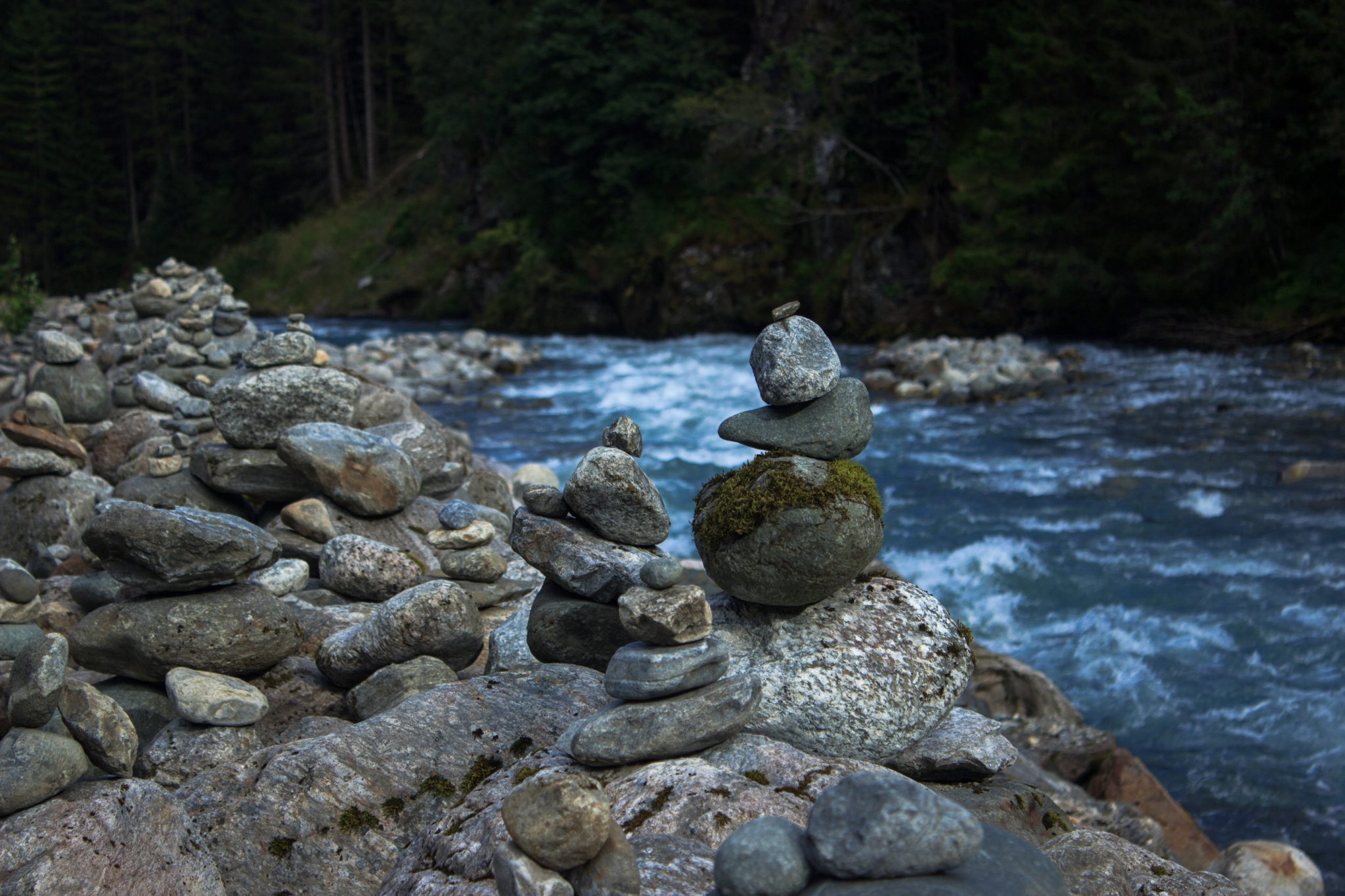 Wandern zum Buarbreen im Folgefonna Nationalpark, Wanderung in der Nähe von Odda mit Aussicht auf den Gletscher Buarbreen und Wasserfälle, aufgetürmte Steine am Fluss im Tal