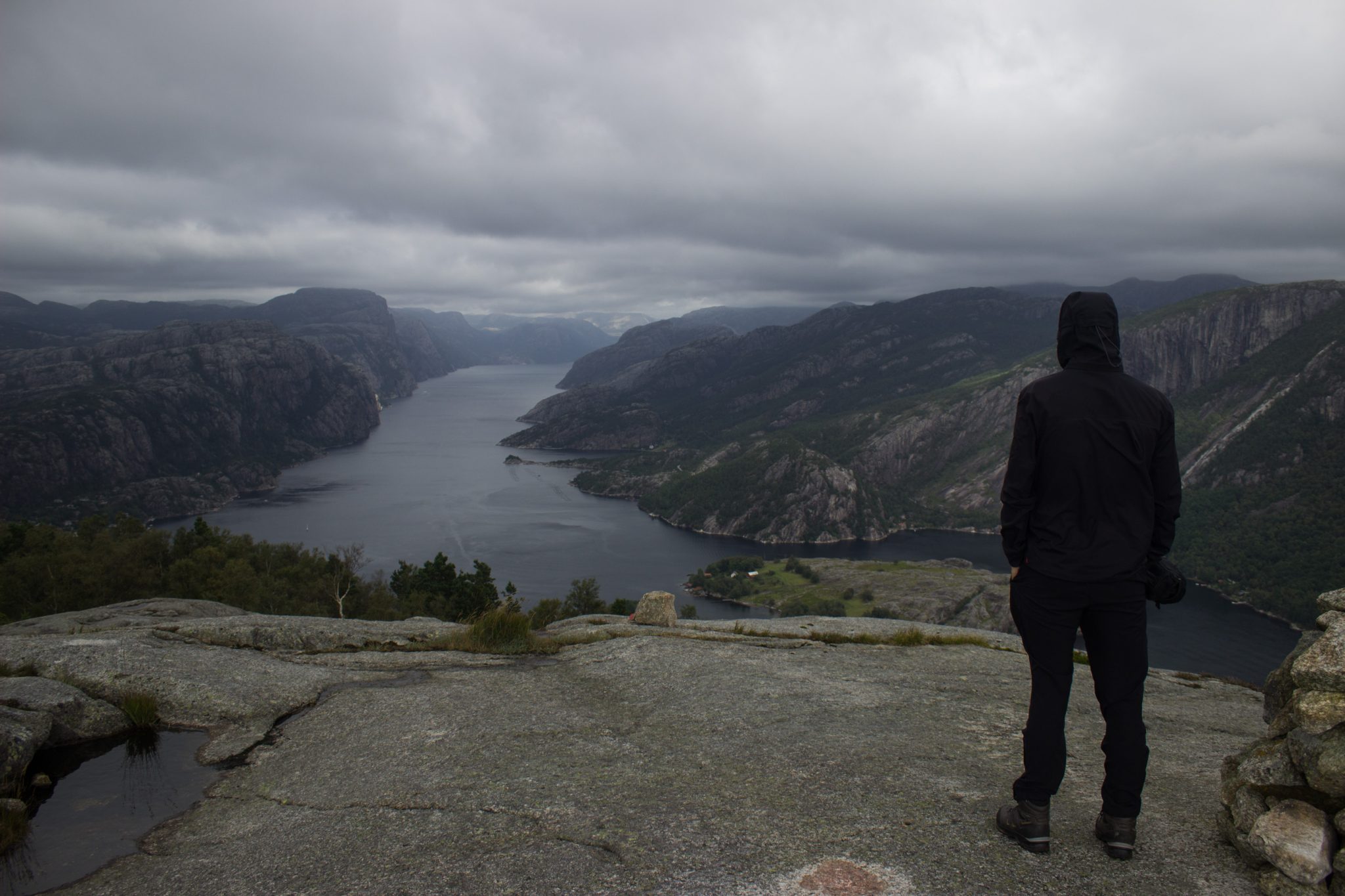 Wanderung beim Lysefjord mit Blick auf den Preikestolen, Startpunkt der Wanderung auf den Sokkaknuten ist beim Lysefjord Hyttegrend, Aussicht auf den Pulpit Rock, Wanderer genießt Aussicht auf den Lysefjord und den Preikestolen