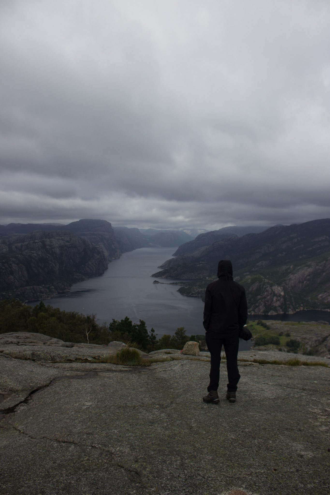 Wanderung beim Lysefjord mit Blick auf den Preikestolen, Startpunkt der Wanderung auf den Sokkaknuten ist beim Lysefjord Hyttegrend, Aussicht auf den Pulpit Rock, Wanderer genießt Aussicht auf den Lysefjord und den Preikestolen