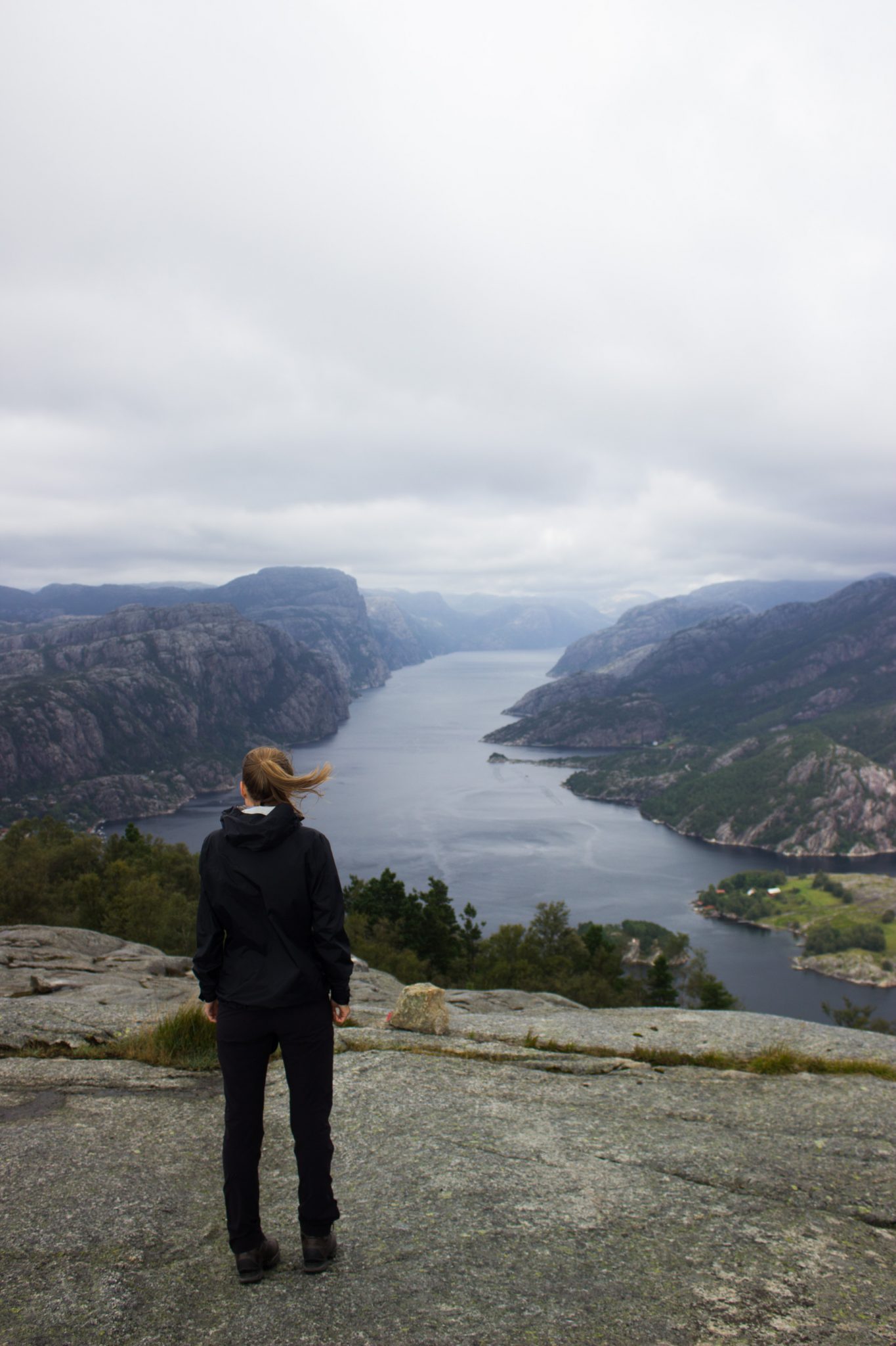 Wanderung beim Lysefjord mit Blick auf den Preikestolen, Startpunkt der Wanderung auf den Sokkaknuten ist beim Lysefjord Hyttegrend, Aussicht auf den Pulpit Rock, Wanderer genießt Aussicht auf den Lysefjord und den Preikestolen