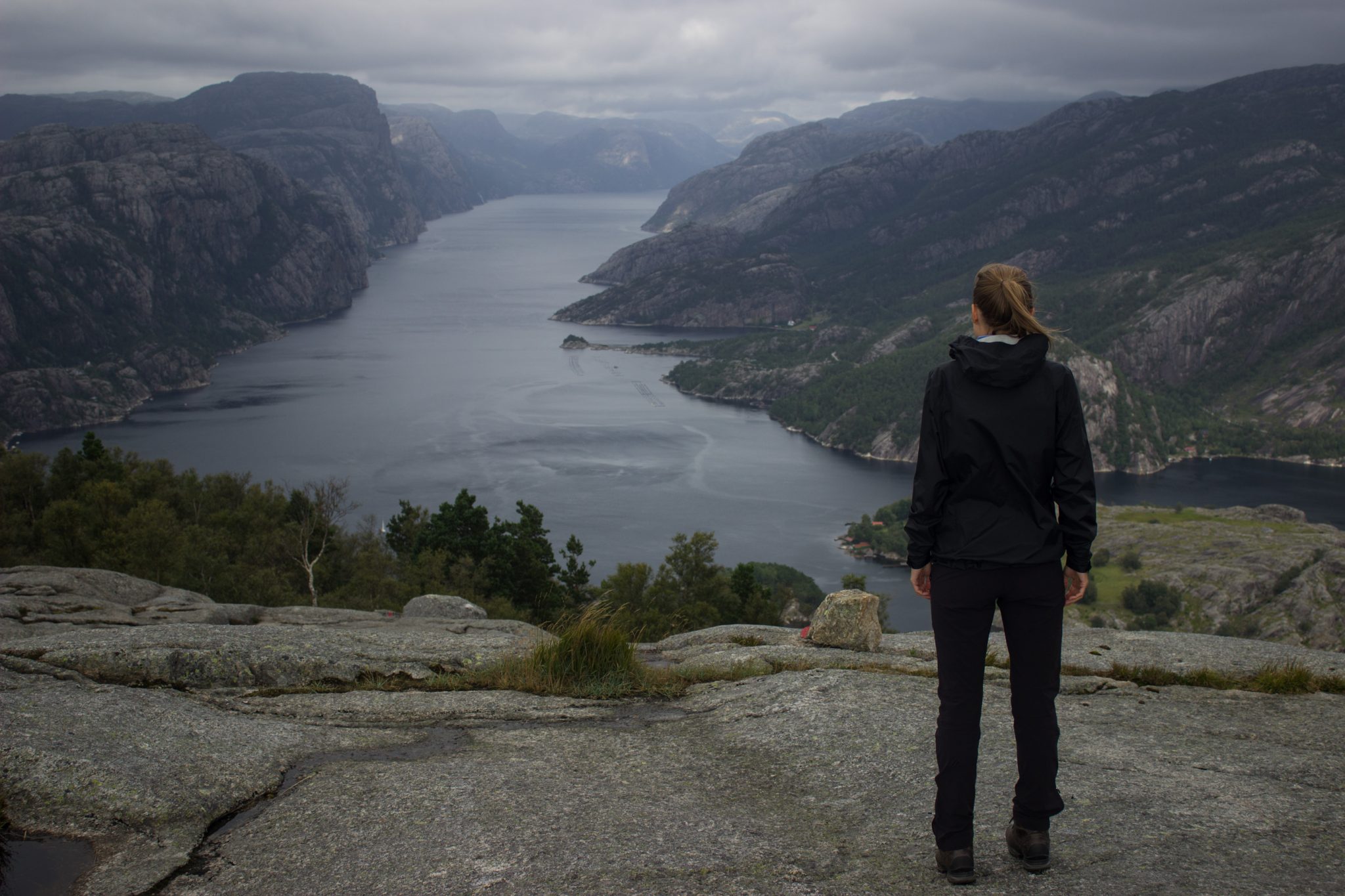 Wanderung beim Lysefjord mit Blick auf den Preikestolen, Startpunkt der Wanderung auf den Sokkaknuten ist beim Lysefjord Hyttegrend, Aussicht auf den Pulpit Rock, Wanderer genießt Aussicht auf den Lysefjord und den Preikestolen