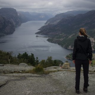 Wanderung beim Lysefjord mit Blick auf den Preikestolen, Startpunkt der Wanderung auf den Sokkaknuten ist beim Lysefjord Hyttegrend, Aussicht auf den Pulpit Rock, Wanderer genießt Aussicht auf den Lysefjord und den Preikestolen