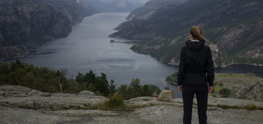 Wanderung beim Lysefjord mit Blick auf den Preikestolen, Startpunkt der Wanderung auf den Sokkaknuten ist beim Lysefjord Hyttegrend, Aussicht auf den Pulpit Rock, Wanderer genießt Aussicht auf den Lysefjord und den Preikestolen