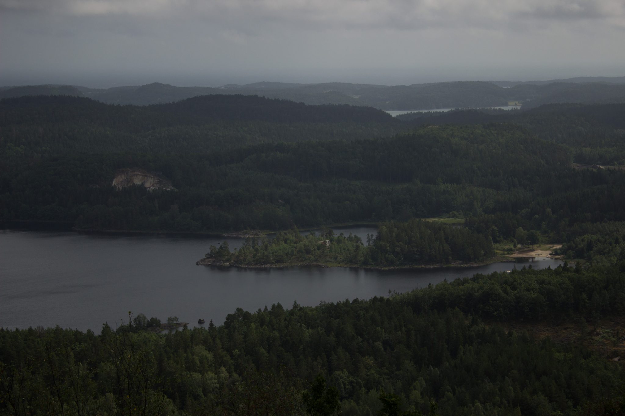 Wanderung im Rossefjellet Naturreservat - Teil der Rundwanderung bei Grimstad in Südnorwegen, nach Wanderung durch schönen und dichten Wald erblickt man diese traumhafte und weite Aussicht auf die umliegenden Seen und kleinen Inseln, dicht mit Wald bewachsene Umgebung, unterwegs in der Natur