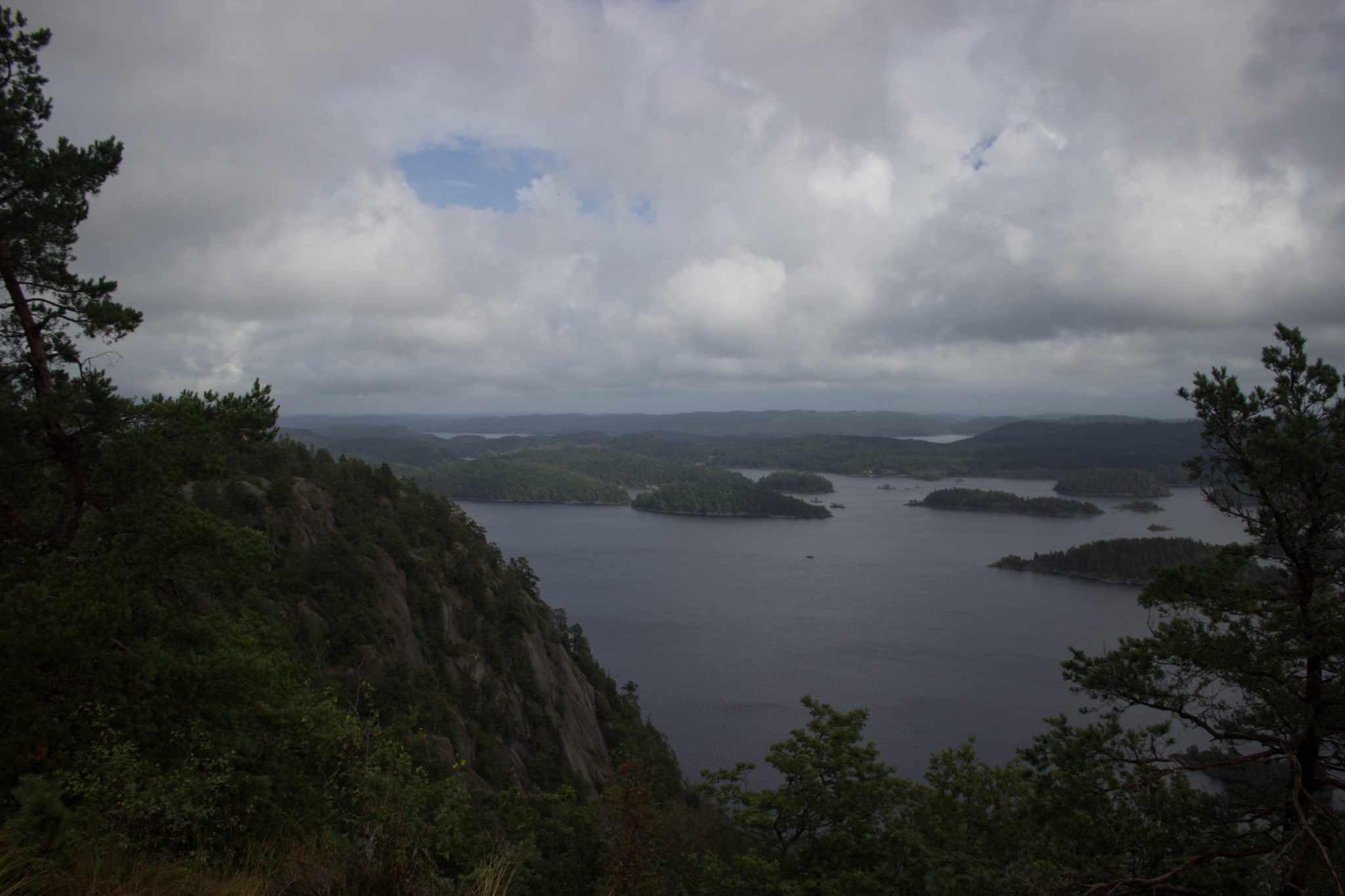 Wanderung im Rossefjellet Naturreservat - Teil der Rundwanderung bei Grimstad in Südnorwegen, nach Wanderung durch schönen und dichten Wald erblickt man diese traumhafte und weite Aussicht auf die umliegenden Seen und kleinen Inseln, dicht mit Wald bewachsene Umgebung, unterwegs in der Natur