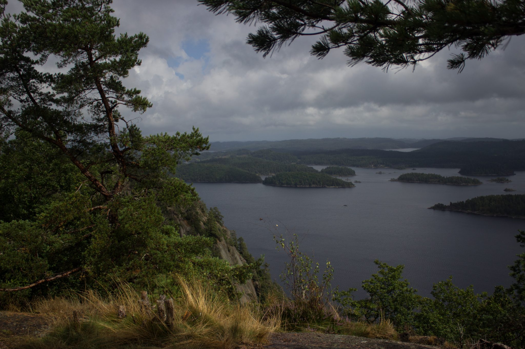 Wanderung im Rossefjellet Naturreservat - Teil der Rundwanderung bei Grimstad in Südnorwegen, nach Wanderung durch schönen und dichten Wald erblickt man diese traumhafte und weite Aussicht auf die umliegenden Seen und kleinen Inseln, dicht mit Wald bewachsene Umgebung, unterwegs in der Natur