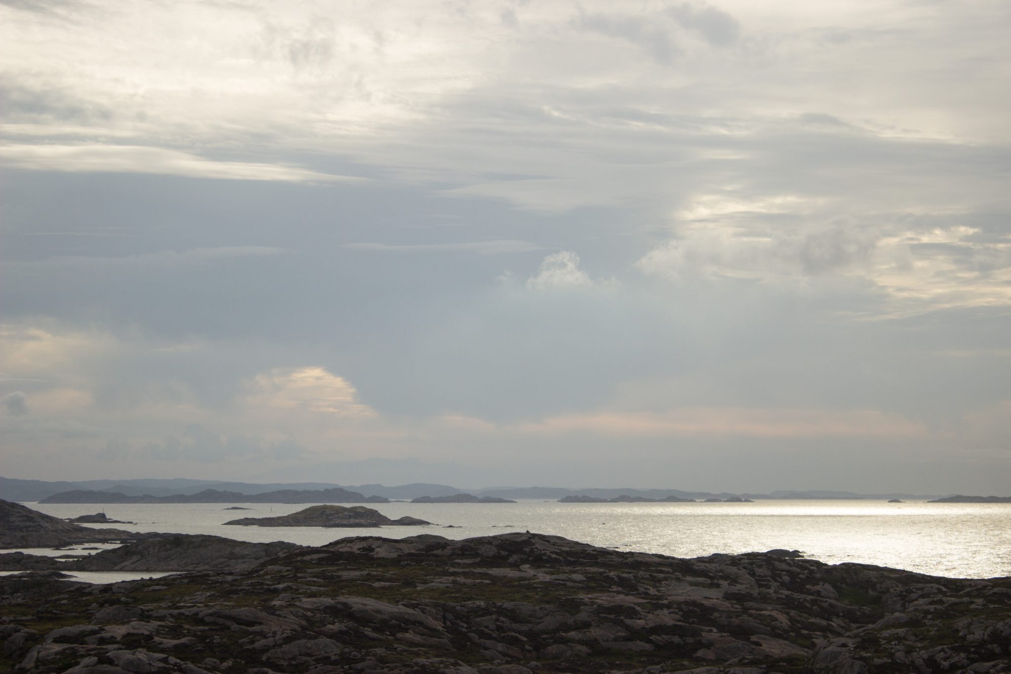 Wanderungen beim Kap Lindesnes, südlichster Punkt Norwegens, am Südkap in Norwegen, Wanderer unterwegs auf schmalem Pfad entlang großer Felsen,  Aussicht auf das weite Meer und die kleinen vorgelagerten Inseln