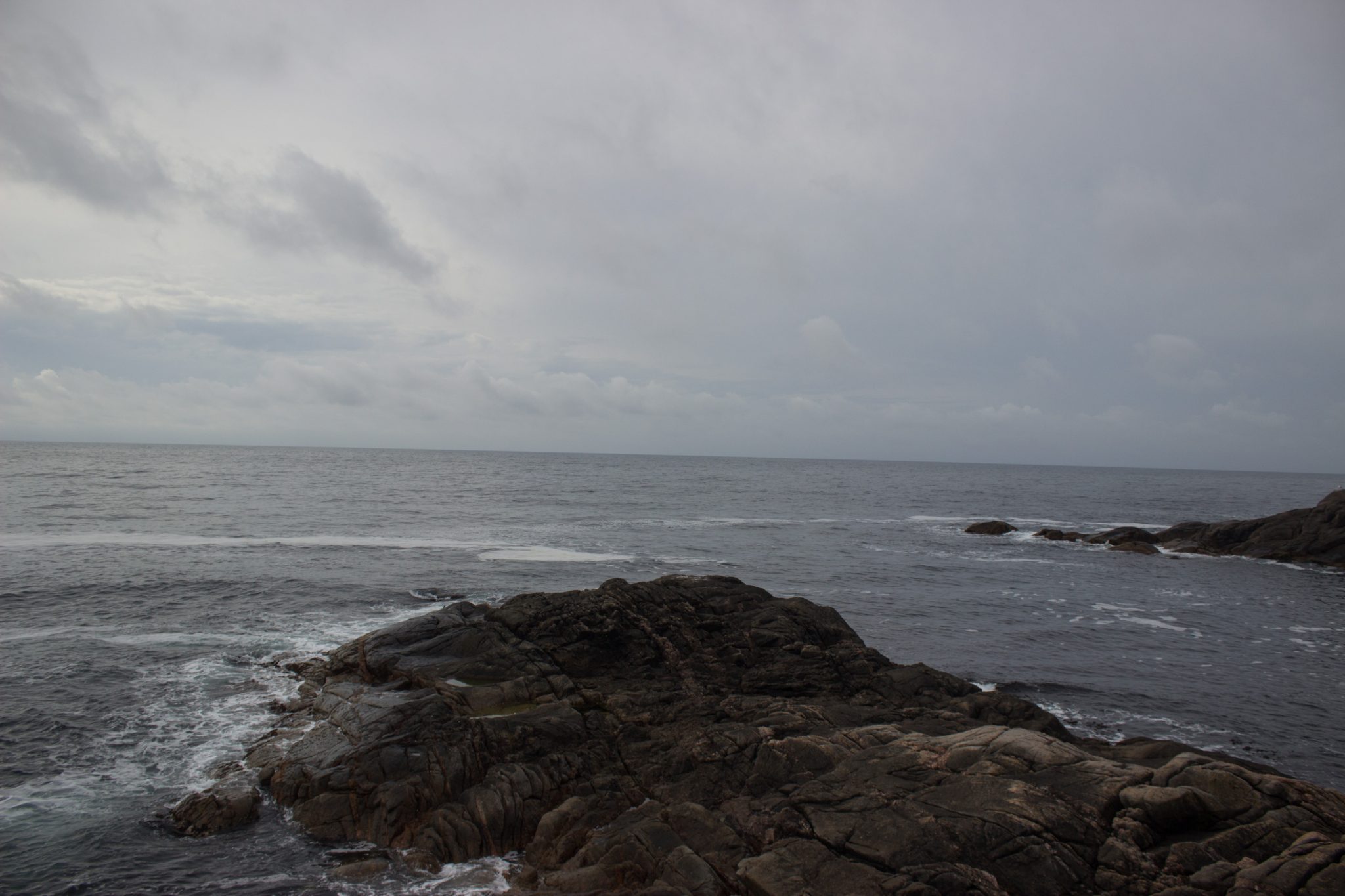 Wanderungen beim Kap Lindesnes, südlichster Punkt Norwegens, Leuchtturm Lindesnes Fyr am Südkap in Norwegen, Wanderer genießt die Aussicht auf das weite Meer