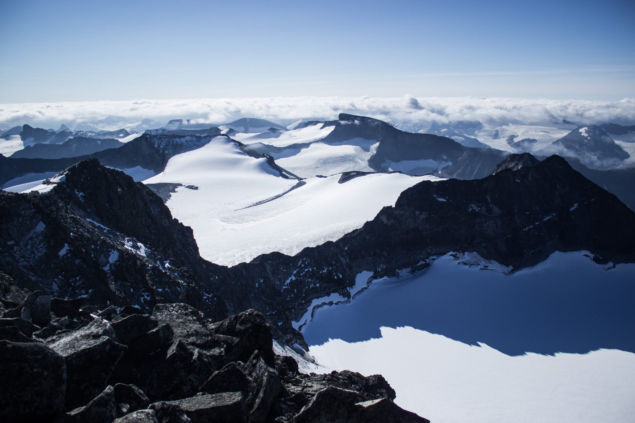 Wanderung auf den höchsten Berg Norwegens - der Galdhøpiggen ab Spiterstulen im Jotunheimen Nationalpark, auch höchster Berg Skandinaviens und Nordeuropas mit 2469 Höhenmetern, Wanderer genießen beeindruckende Aussicht auf die Bergwelt am Gipfel des Galdhøpiggen