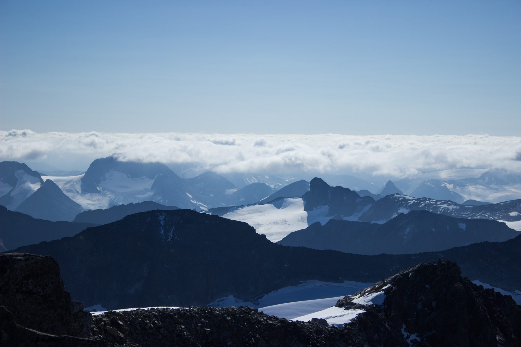 Wanderung auf den höchsten Berg Norwegens - der Galdhøpiggen ab Spiterstulen im Jotunheimen Nationalpark, auch höchster Berg Skandinaviens und Nordeuropas mit 2469 Höhenmetern, Wanderer genießen beeindruckende Aussicht auf die Bergwelt am Gipfel des Galdhøpiggen bei schönstem Sonnenschein