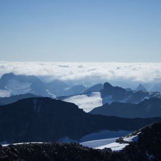 Wanderung auf den höchsten Berg Norwegens - der Galdhøpiggen ab Spiterstulen im Jotunheimen Nationalpark, auch höchster Berg Skandinaviens und Nordeuropas mit 2469 Höhenmetern, Wanderer genießen beeindruckende Aussicht auf die Bergwelt am Gipfel des Galdhøpiggen bei schönstem Sonnenschein