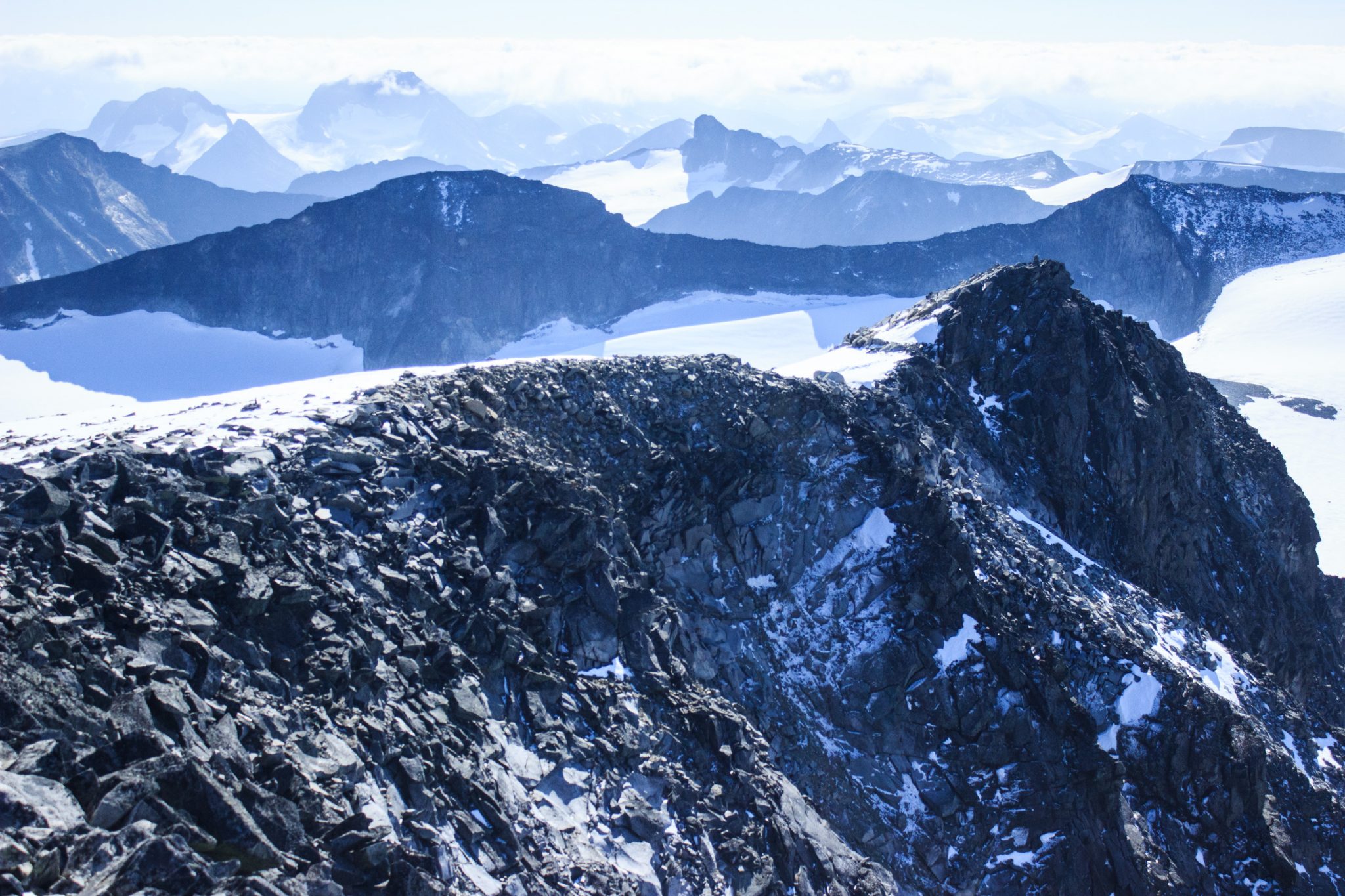 Wanderung auf den höchsten Berg Norwegens - der Galdhøpiggen ab Spiterstulen im Jotunheimen Nationalpark, auch höchster Berg Skandinaviens und Nordeuropas mit 2469 Höhenmetern, Wanderer genießen beeindruckende Aussicht auf die Bergwelt am Gipfel des Galdhøpiggen bei schönstem Sonnenschein