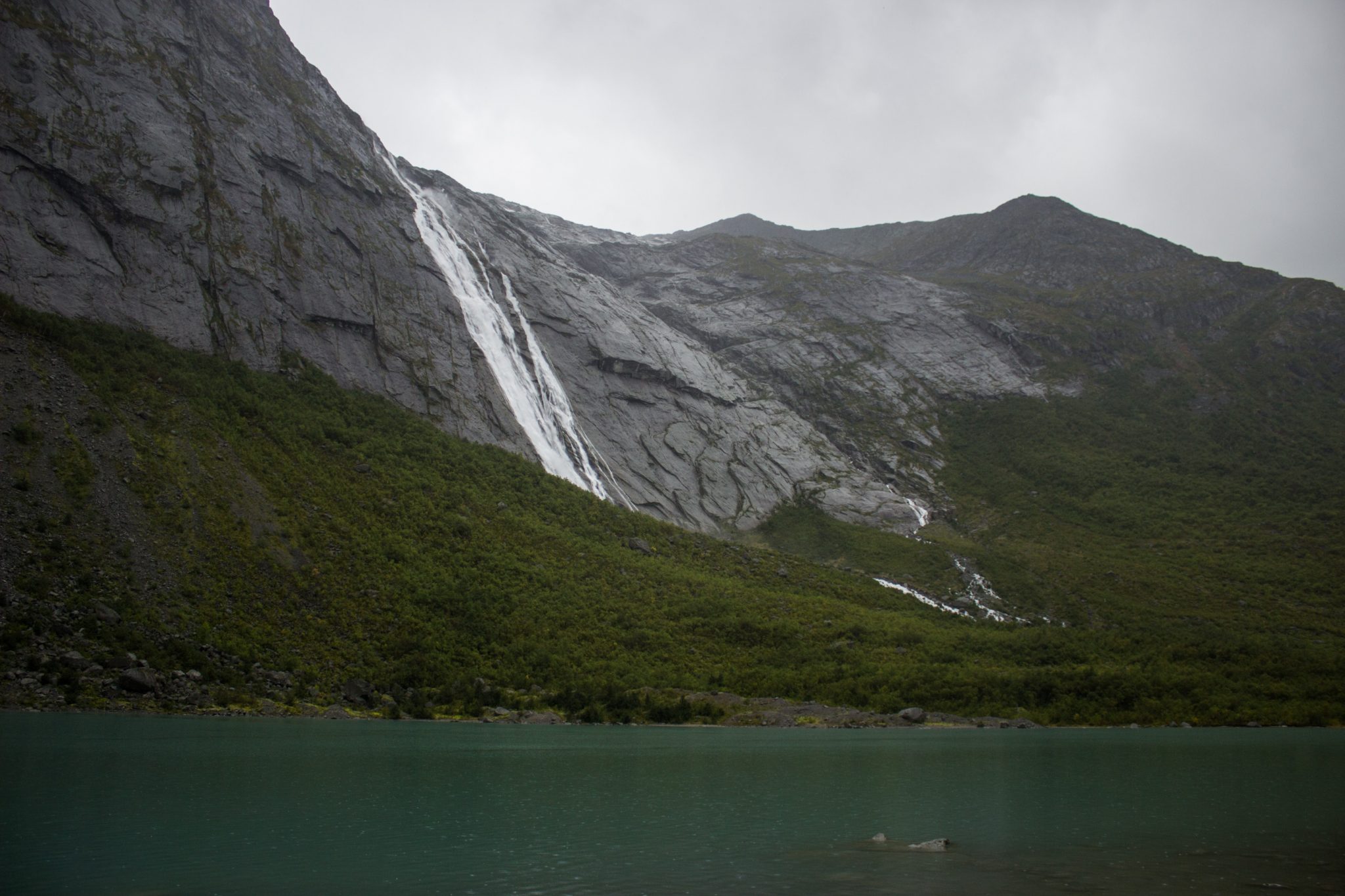 Wanderung zum Briksdalsbreen Gletscher, Seitenarm des Jostedalsbreen, Wandern im Jostedalsbreen Nationalpark in Norwegen, sehr beeindruckende Landschaft im Briksdal, Blick auf einen Wasserfall und den Gletschersee, umgeben von Bergen